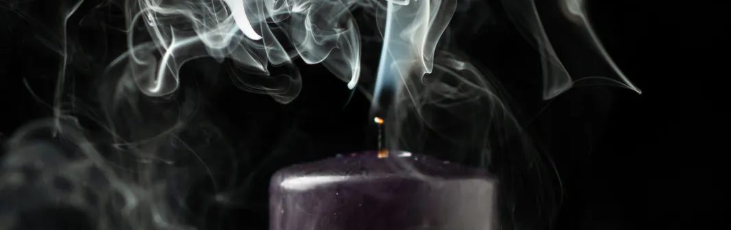 Smoky notes — smoke curling from a dark candle