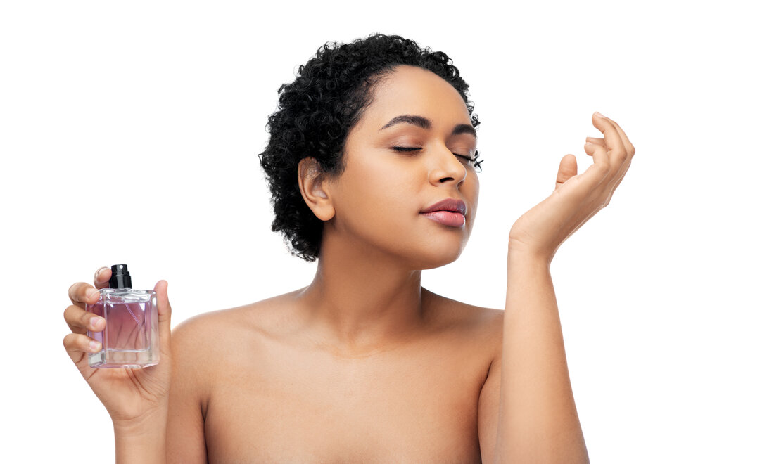 A young woman smelling a fragrance strip, natural unposed expression